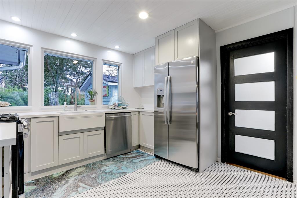 THE KITCHEN IS FINISHED OFF WITH A RECENT STAINLESS STEEL GAS RANGE, APRON SINK AND REFIGERATOR THAT WILL STAY WITH THE HOUSE.