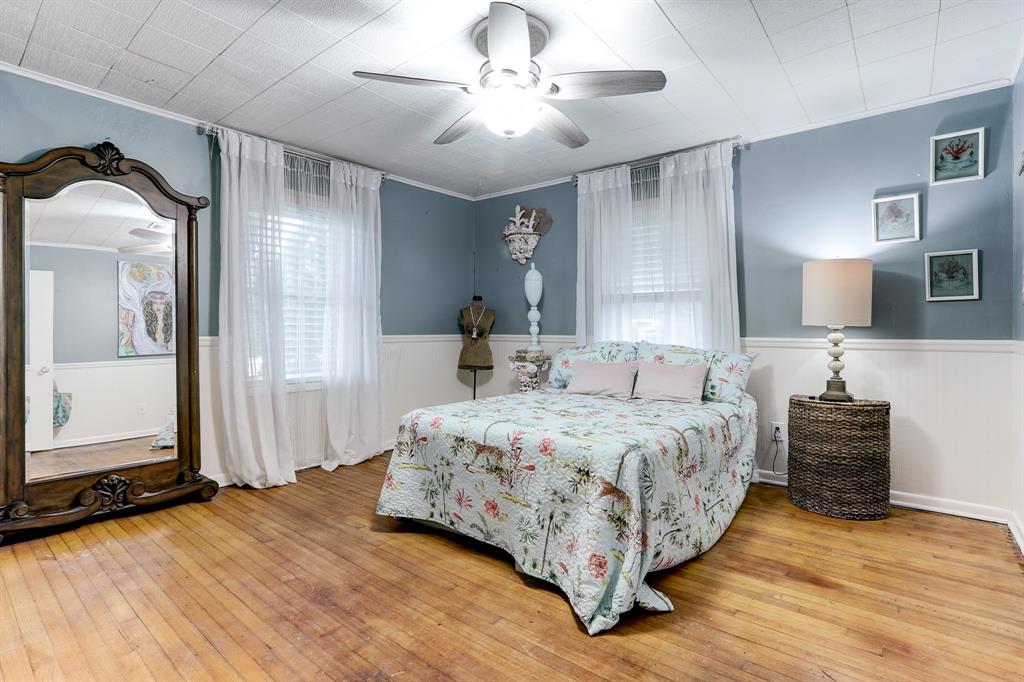 CUTE PRIMARY BEDROOM WITH WOOD FLOORS AND A BEADBOARD HALF-WALL ADDING EVEN MORE CHARACTER.