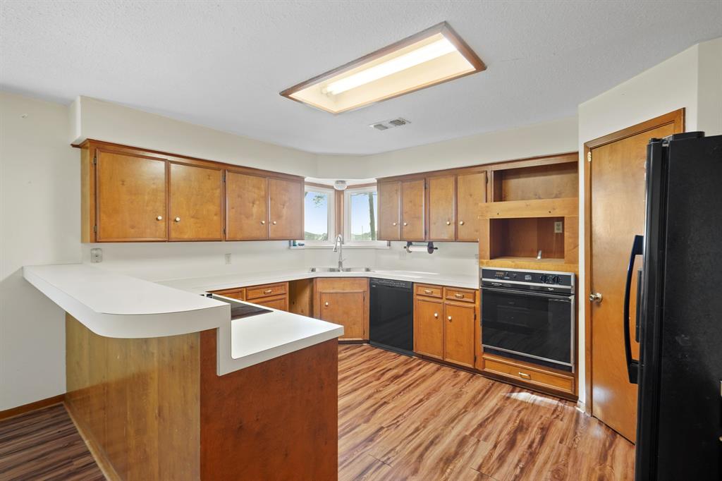 Open kitchen with corner picture windows above sink.