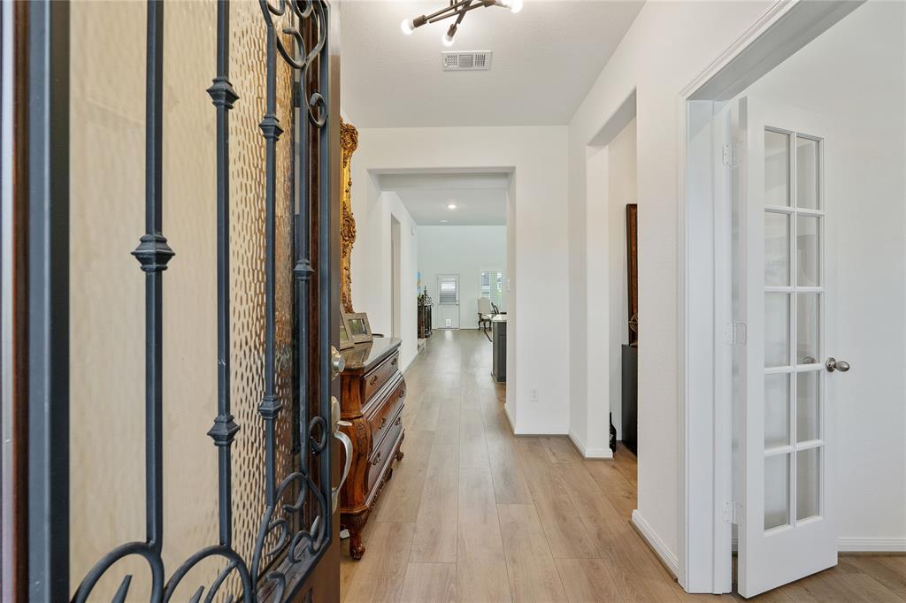 Long foyer showcasing extended hallway & luxury planks.