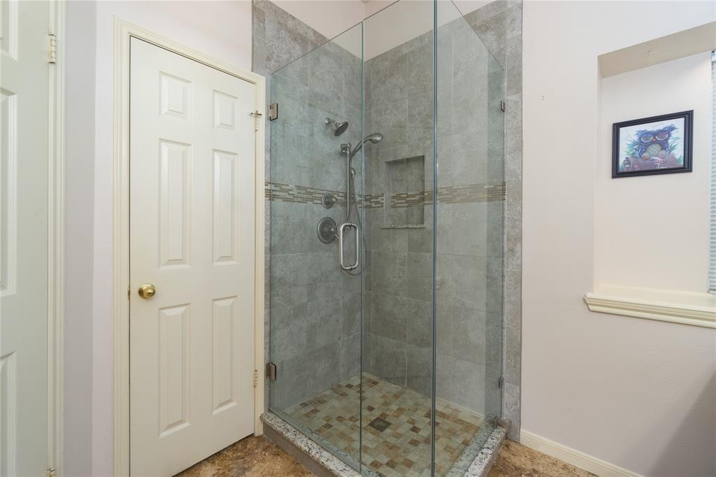 Beautifully updated walk in shower is located next to large walk in closet.