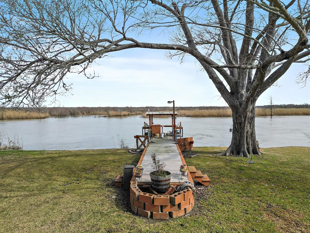 Pier at river, shaded by large oak tree