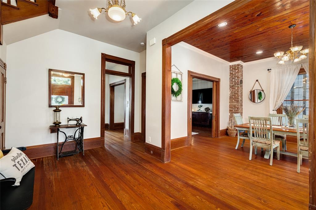 When you pass through the foyer, the dining room is on your right and offers a large well lit space with original ceilings, views of the gorgeous property, charming original brick flue, and a built in wall cabinet.