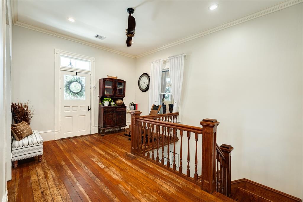 At the top of the stairs is a large bonus space that makes the perfect sitting nook or home office space. Notice the door to the upper gallery front porch.