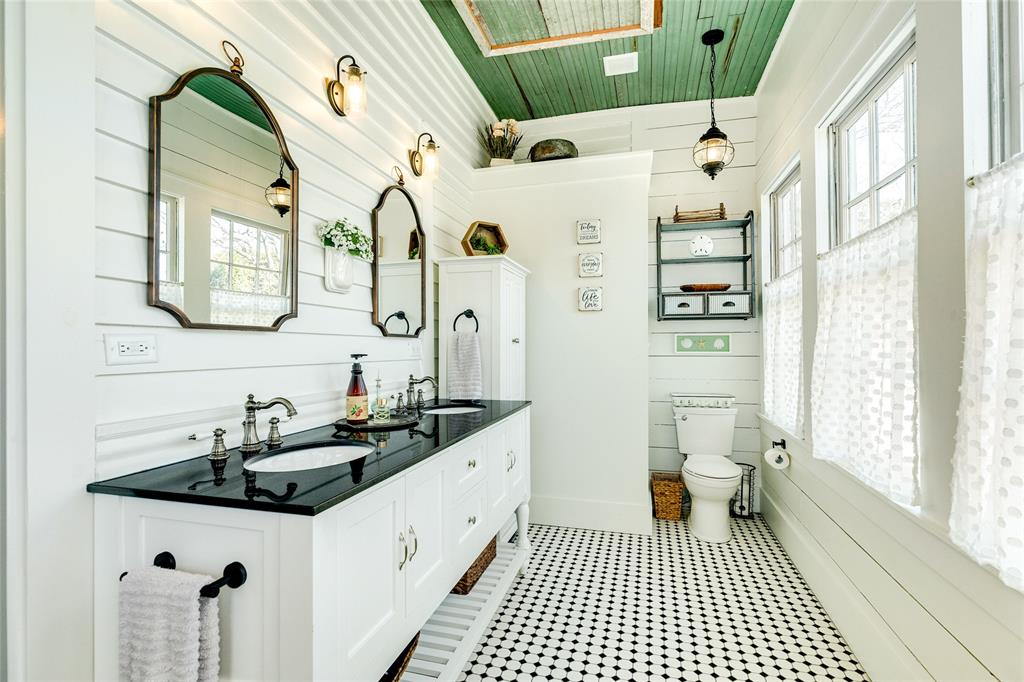 Another view of the primary en-suite. Notice the vintage tile pattern, light fixtures, and overall aesthetic. This space oozes a charming lifestyle.