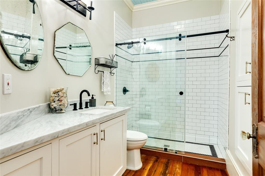 The second full bath upstairs offers ample storage, timeless marble and vintage appeal.