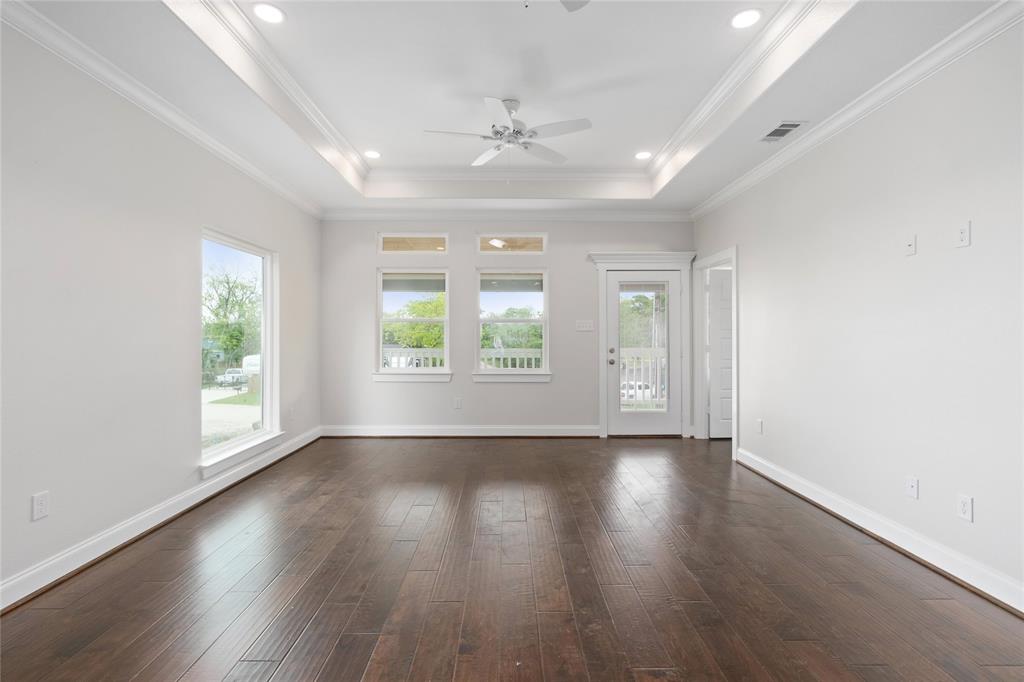 Open family room with lots of windows and door leading to covered outdoor deck