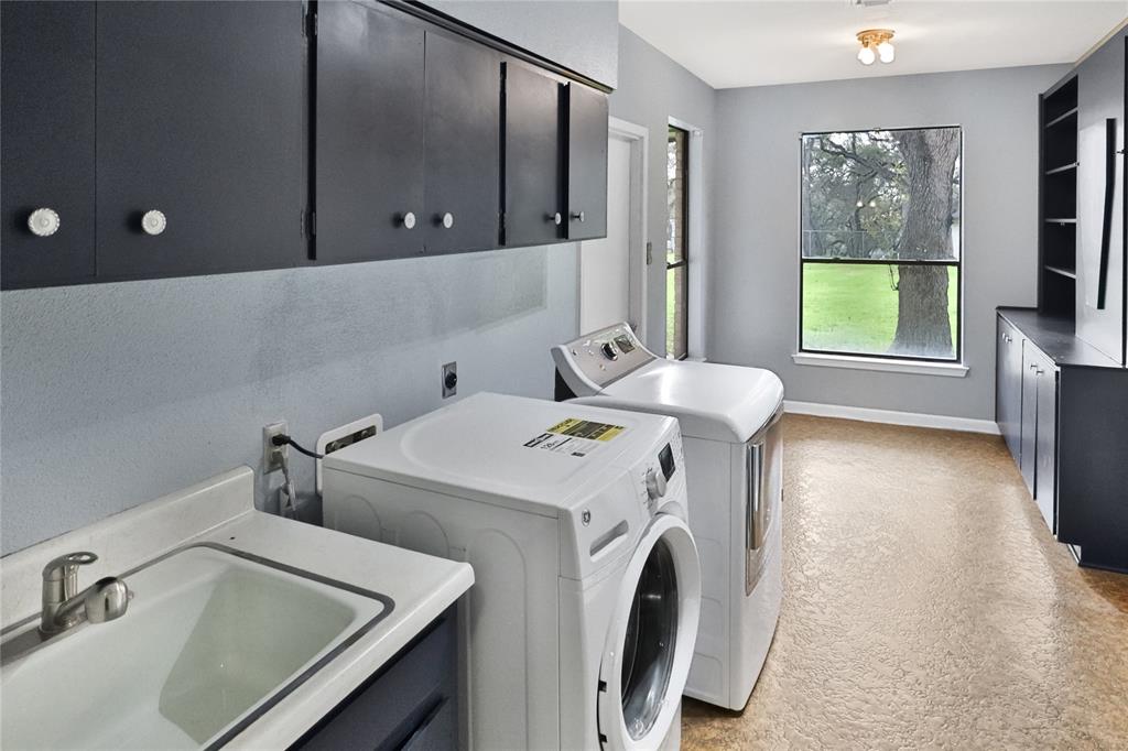 Large utility room with tons of space and custom cabinetry. plenty of space for deep freezer / extra refrigerator