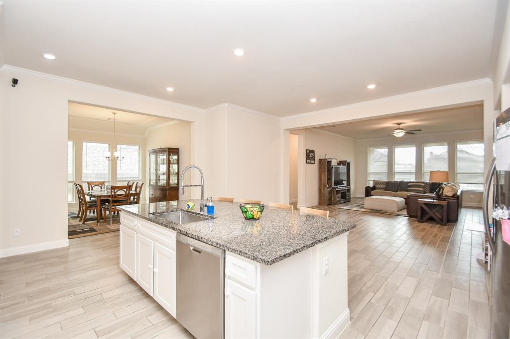 Marvel at the panoramic view of the family area and dining room from this exquisite island kitchen.