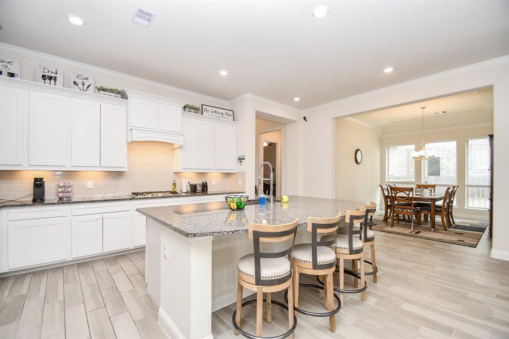 This open and inviting kitchen, breakfast bar, and dining room serve as the perfect centerpiece for this sprawling 5-bedroom home.