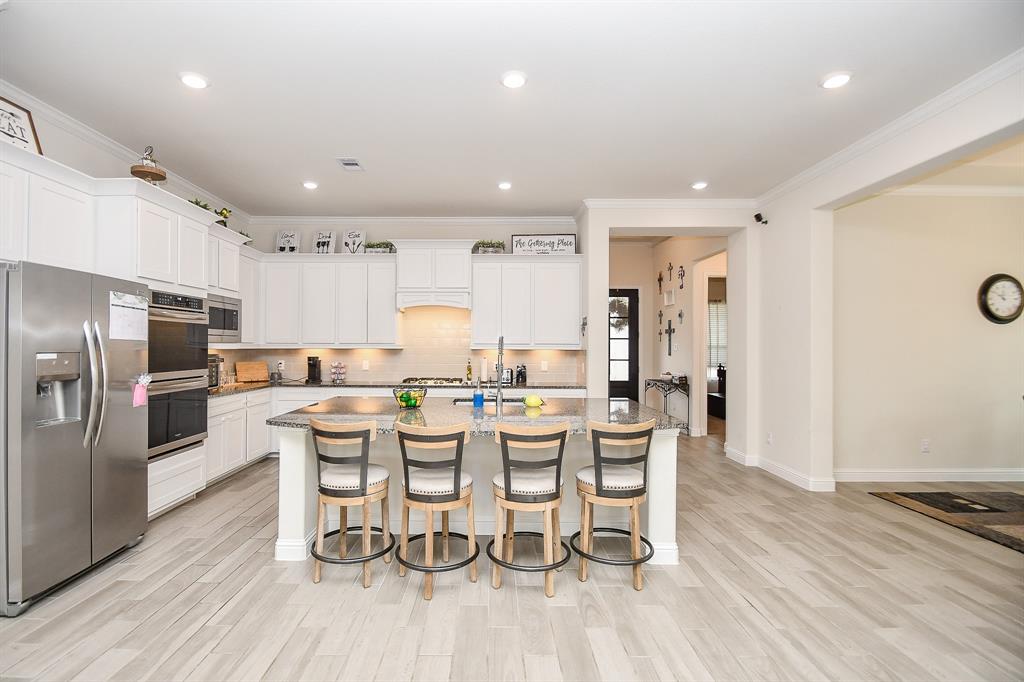 The large breakfast bar is versatile for any meal of the day, complementing the beautiful kitchen with its tall cabinets and granite countertops.