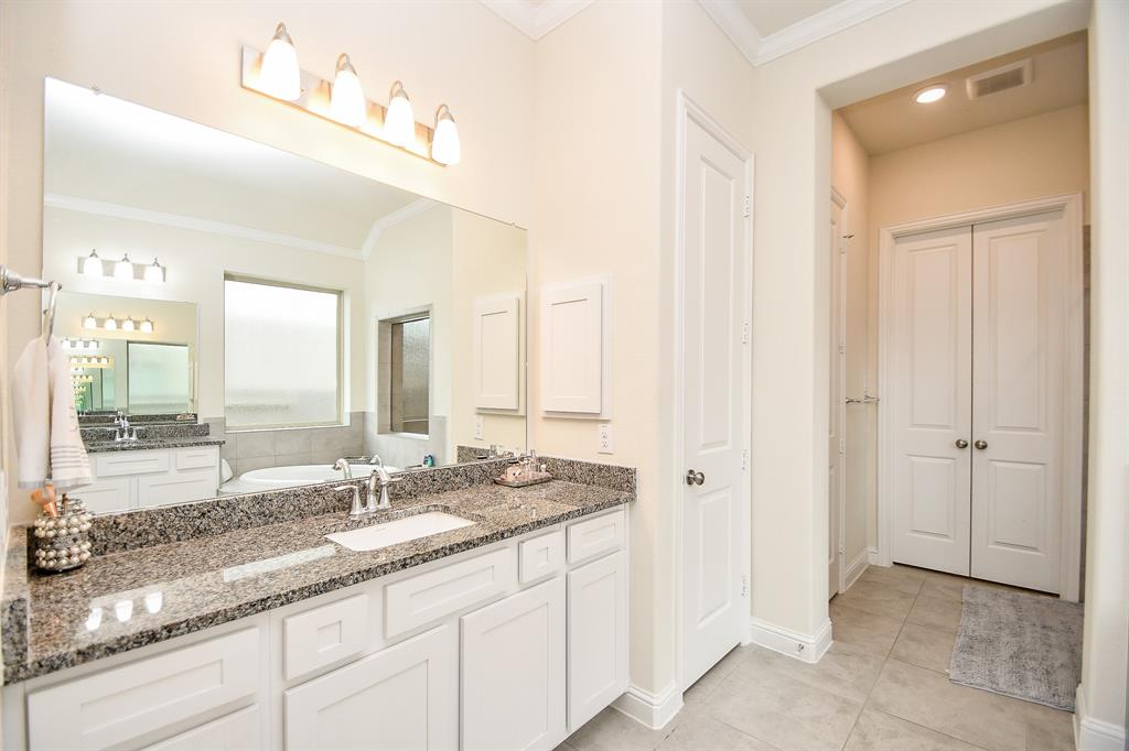 Adorned with beautiful mirrors, granite countertops, and ample storage space, both vanities in this luxurious bath exude elegance.