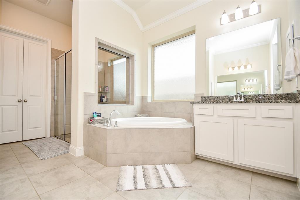 Experience spacious luxury in this ensuite, featuring a large soaking tub and walk-in shower.