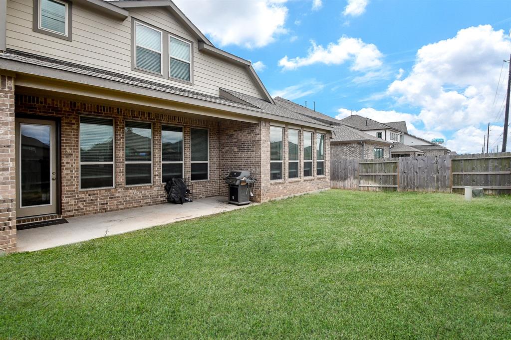 From this spacious backyard view, admire the floor-to-ceiling windows that adorn this beautiful home, allowing ample natural light to flood the interior.