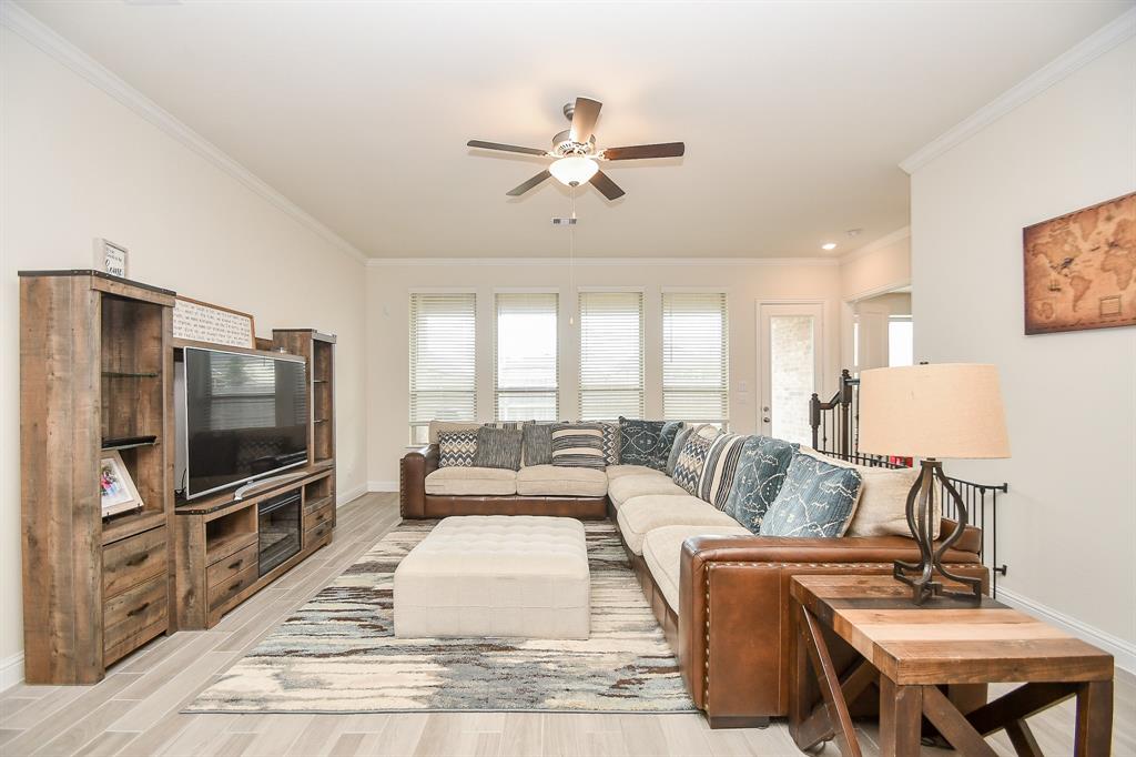 Relax in style in this spacious family room, perfect for your oversized furniture, complemented by high ceilings and floor-to-ceiling windows that elevate the ambiance.