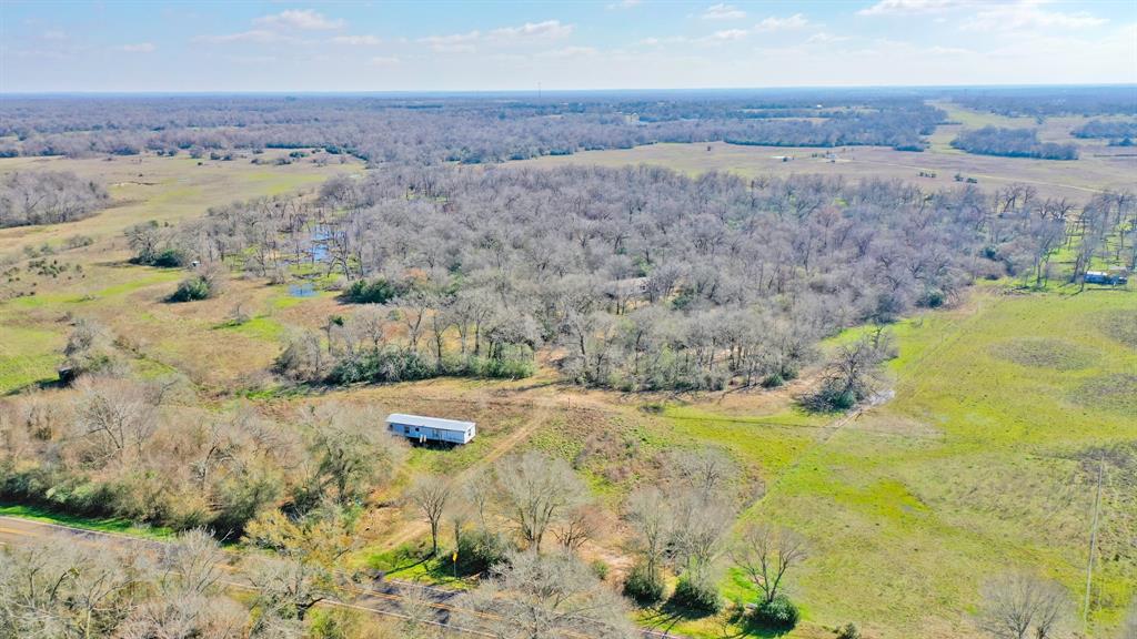 Sitting in the picturesque landscapes of Madisonville, Texas, this 10-acre ranchette offers a unique blend of tranquility and natural beauty. Perfectly situated for those seeking a peaceful retreat, the land showcases the best of Country living in a highly sought after area of Madison County.  There are 2 mobile homes on the property that can be renovated or removed, the property has partial fence, electricity is nearby and there is High-Prairie rural water at the road.  The property presents approximately 20% open and 80% wooded boasting various hardwoods, softwoods, underbrush and native grasses.  This nice-sized parcel boasts provides numerous opportunities for outdoor activities, making it an ideal canvas for creating your dream estate. Whether you envision a private ranch, a custom-built home, or recreational pursuits, this property can accommodate a variety of lifestyles.