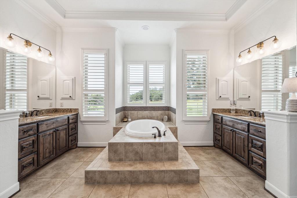 Light and bright, the bathroom also features dual vanities