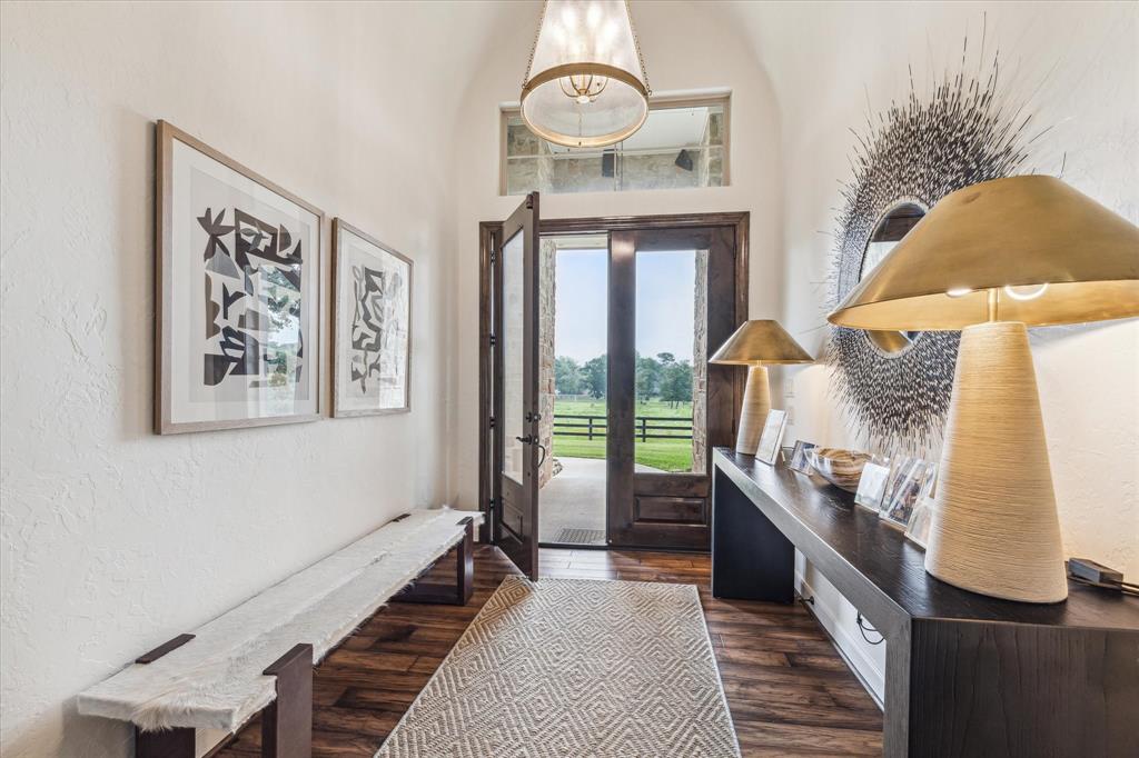 The home has a grand foyer with a breathtaking view of the front pasture and pond.  Custom lighting by Visual Comfort.