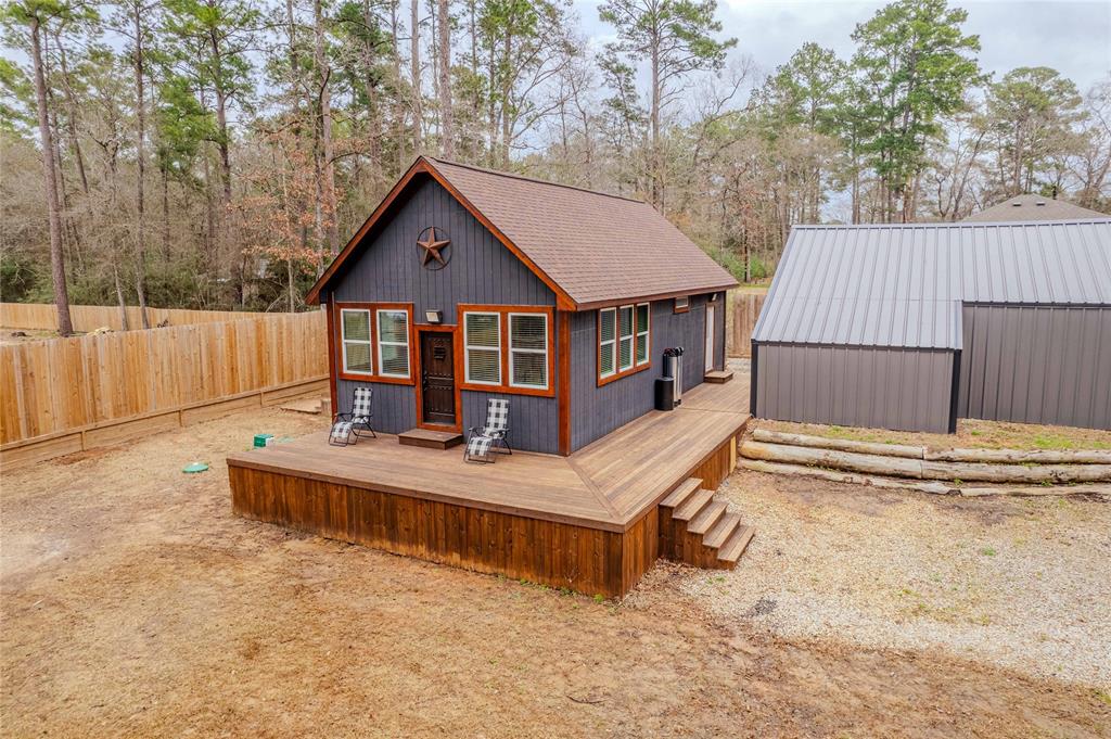 WOW! UNIQUE opportunity to own a RECENT CUSTOM BUILT home on over HALF an ACRE and still in a wooded area to enjoy privacy, peace, and quiet! LOTS of space to spread out and enjoy the elbow room this property provides. Hidden Forest Estates is nestled in the Sam Houston National Forest so you'll love the drive home each day, and all the weekend activities to do in the park. You are also VERY CLOSE TO LAKE CONROE! You can be on the lake in minutes and enjoy all the fun water activities on a lake. This home is custom built and LOOKS GREAT! You'll love the huge wrap around porch, and the finishes in this home. Rustic, but modern, and well appointed. All you need with a nice open living space, kitchen, eating area. There is a loft for a second space or bedroom area, and the primary bedroom is quite large! There are multiple out buildings for storage, workshop, vehicles, etc. New fence as well and the home is still like new! Come get this great opportunity at a great price!