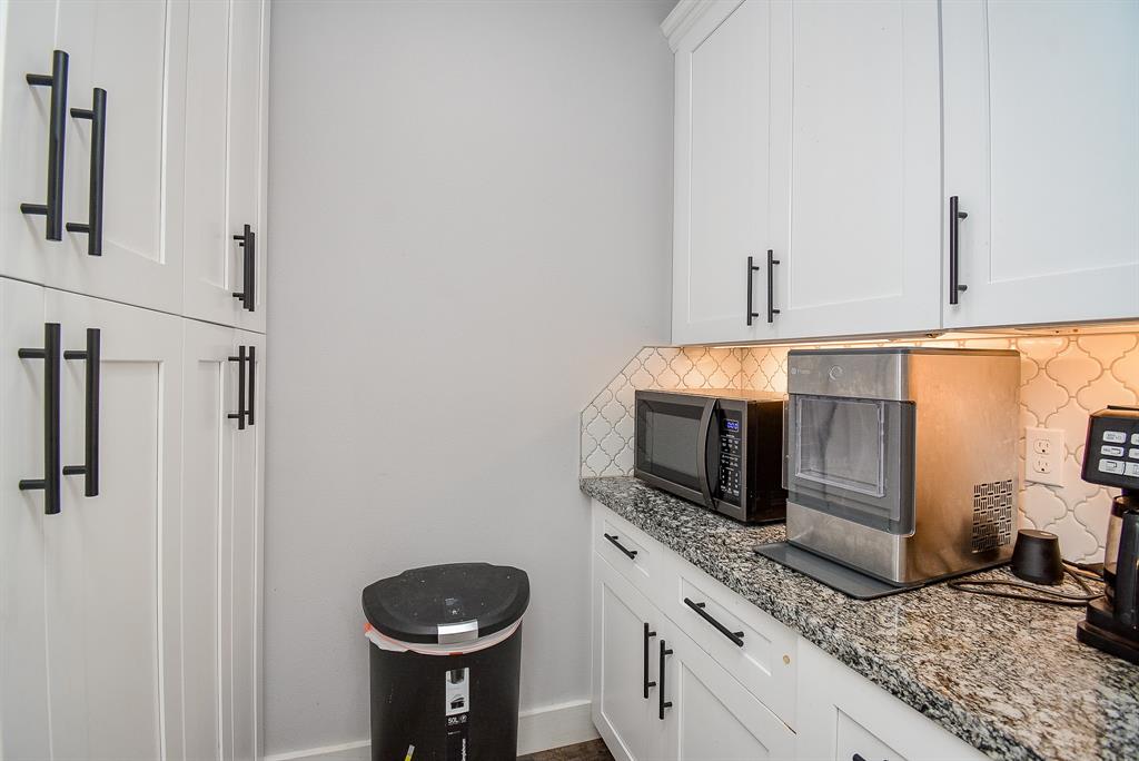 Gorgeous, custom cabinetry (up and down) are accented with black wrought iron accessories, with counter space, galore!