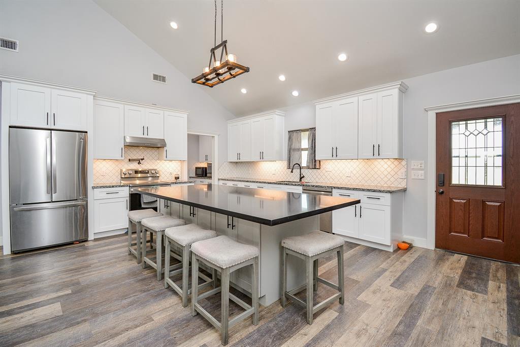 Imagine everyday or special day meals here in your glistening kitchen; lined up and down with sleek white cabinetry; complementary earth tones on the tile backsplash; with room galore on this exquisite island for lots of comfy stools and great mingling!