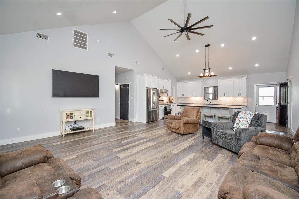 This marvelous, open, airy living/family area is highlighted with a glorious high ceiling and dramatic recessed lighting, cool toned walls and durable, rich laminate? vinyl? linoleum ? flooring.