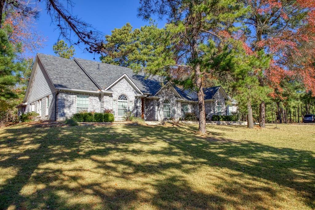 This gorgeous Custom home sits on apprx. 10 ac with an abundance of trees. Private gated entry. Asphalt drive leading to the home passing a beautiful Koi Goldfish pond. Property has a 5500 sq ft bldg with 2000 sq ft of shop with HVAC, bath. Nice 3 stall horse area with tack room. 15 X 60 storage bldg and 20 x 40 RV parking area. Garden site with well and new pump. Home offers 4 bd, 3.5 baths, study/office, formal dining, large primary bedroom with two vanities plus soak tub & separate shower. Remodeled kitchen with butcher block topped island work area, granite countertops, & premium appliances. Refrigerator in kitchen stays. Storm shelter in home. Large covered patio at back of home. Property is fenced and has a fenced back yard area. New roof 2023.