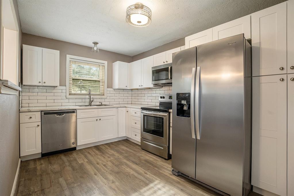 A look at the kitchen toward the gas fireplace.  The door on the left leads to the laundry and family/game room.