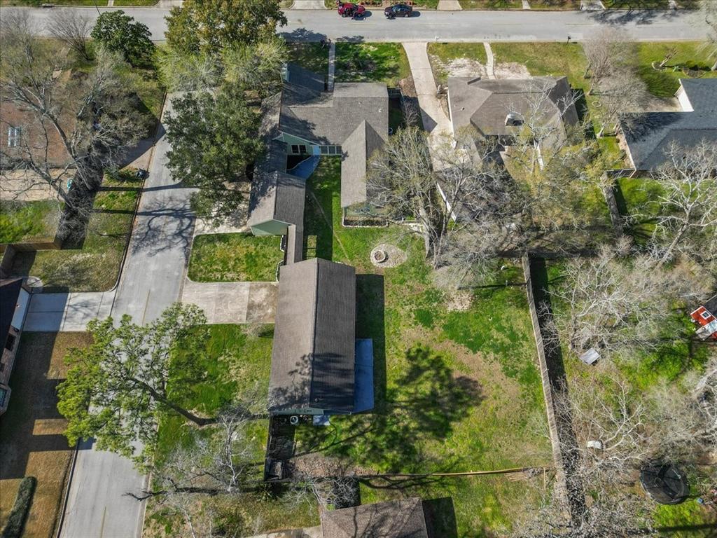 An aerial shot captures the grandeur of a home situated on an oversized corner lot, surrounded by mature trees.