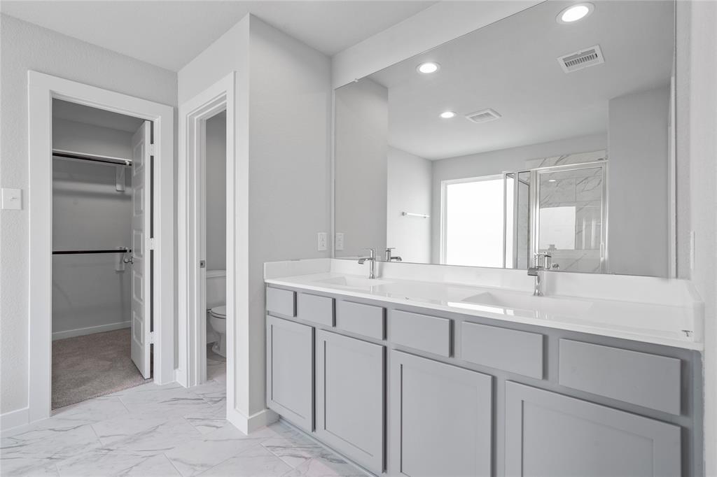 This large master bath is spacious enough to share! With separate vanities, large closet space, plentiful cabinet and counter space, you are sure to have private area while sharing this bathroom!