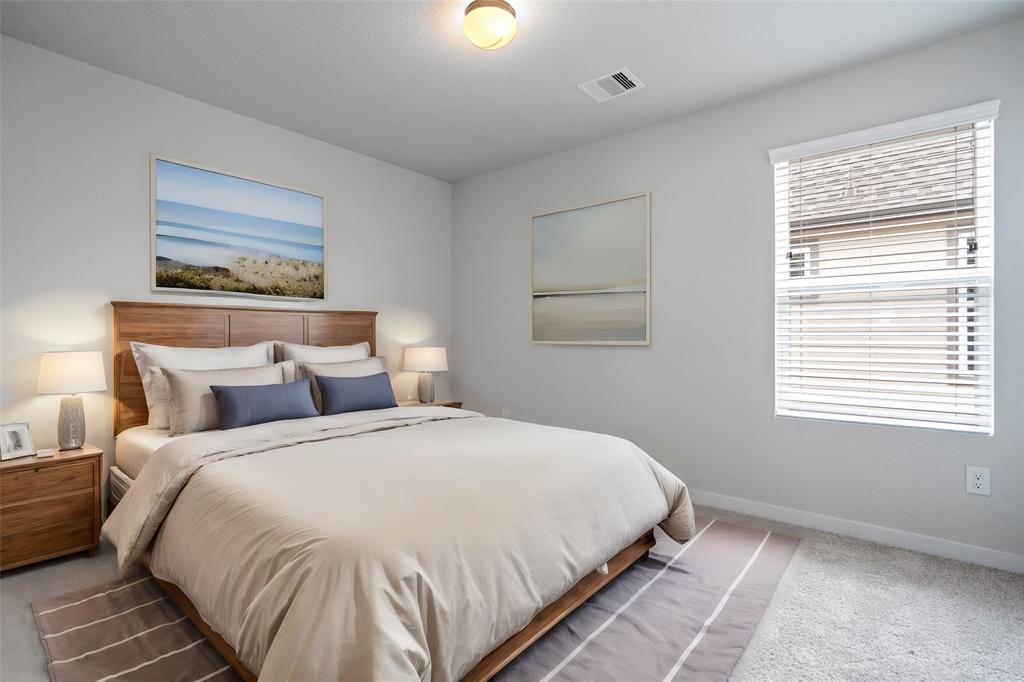 Secondary bedroom features plush carpet, custom paint and a plenty of windows allowing natural light to come in.