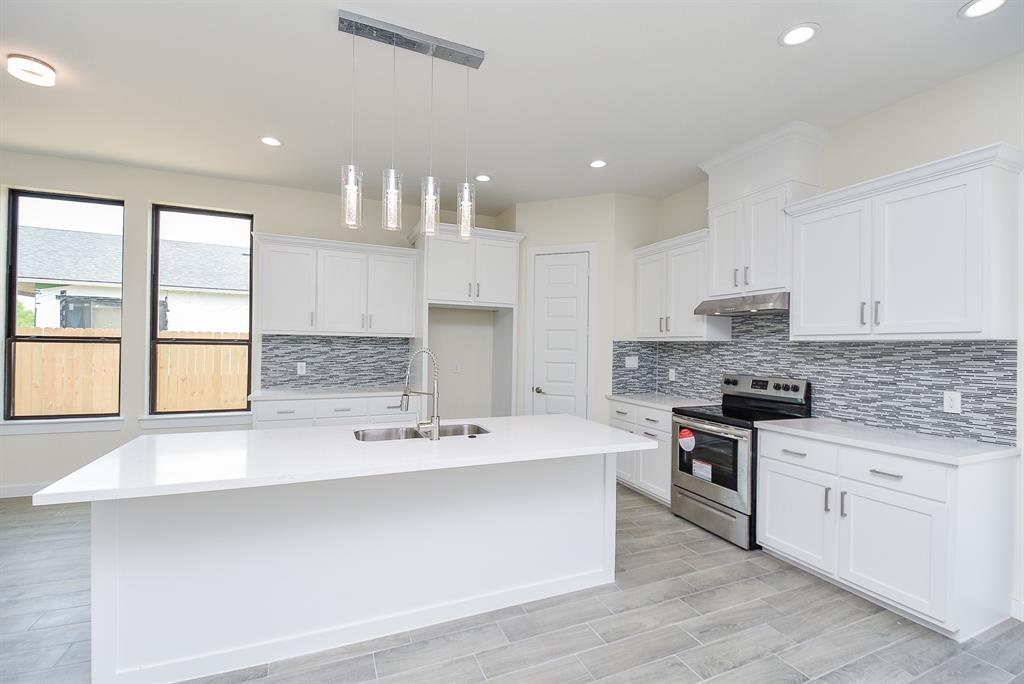 Large center island with Quartz countertop and sink. The perfect place to gather for your morning cup of coffee.