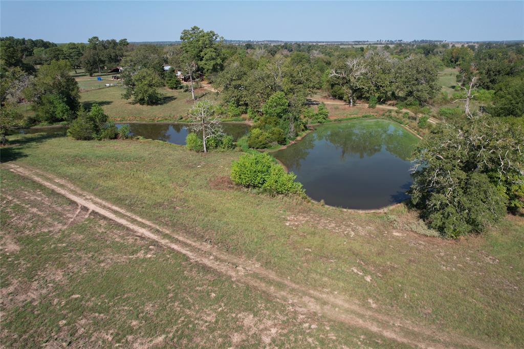 PEACEFUL, COUNTRY SETTING! This hilltop property has so much to offer! From the moment you enter the gate, you will love the pretty rolling coastal hay fields and scattered trees. The large lake is stocked with bass to enjoy fishing. There are two other ponds on the property that make a great water source for livestock. Big Creek boarders one end of the property – this creek has water year-round, attracting lots of local wildlife. The owner reports great deer hunting as well. There is a camp house with four bedrooms and two bathrooms that makes for a perfect weekend get-a-way. The home needs a little TLC, but is great for camping and it’s connected to its own private water well. There is an older barn on the property for storage. If you’re wanting a private slice of heaven, this is the spot! Call today to schedule a private tour of this one-of-a-kind property.