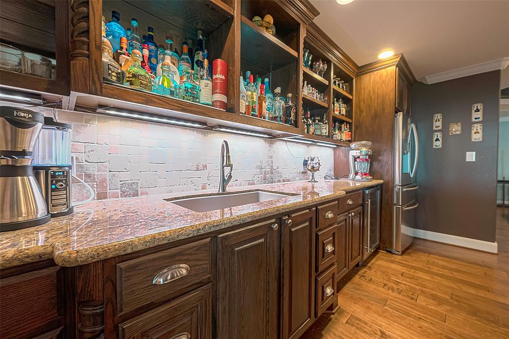 A close-up view of the cabinets and countertop behind the bar -- note the large sink and open upper cabinets to show off your collection.