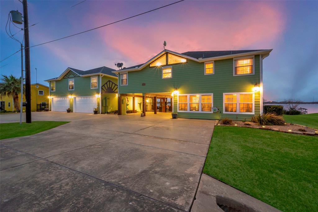 Overview of the entire property at dusk.  Note the oversized 4-car garage and enormous circular driveway. The media room / game room are located over the garage space.