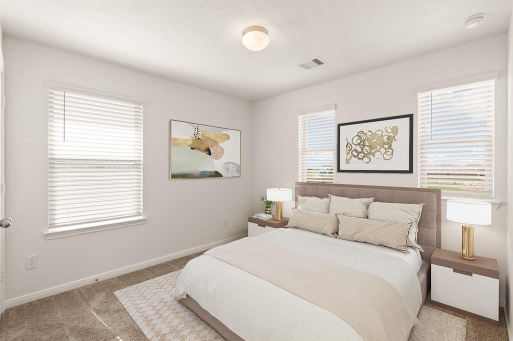 Secondary bedroom features plush carpet, and a large windows with privacy blinds.