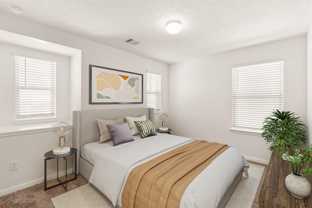 Secondary bedroom features plush carpet, and a large windows with privacy blinds.