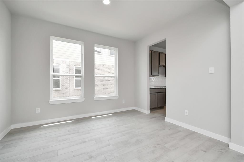 An inviting dining space seamlessly woven into the open concept, connecting the family room and kitchen. Revel in the stunning floors, soothing paint palette, and the crowning touch of a sleek chandelier – a perfect setting for shared meals and cherished moments.