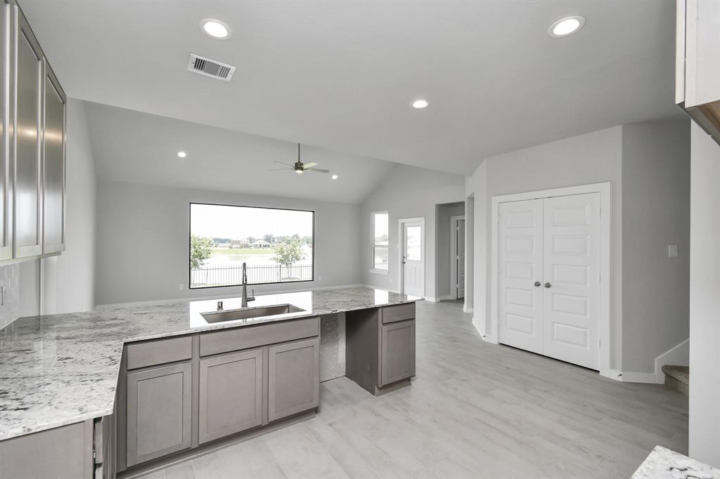 Culinary haven, featuring granite countertops, a tile backsplash, stainless steel appliances (to be installed), and 42” upper cabinets.