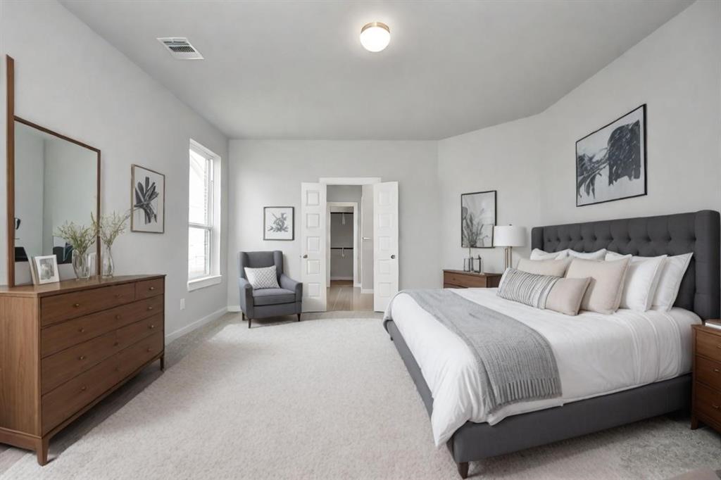 Escape to tranquility in this spacious primary room, adorned with plush carpeting and bathed in the soothing hues of warm paint colors, creating a cozy retreat for relaxation.