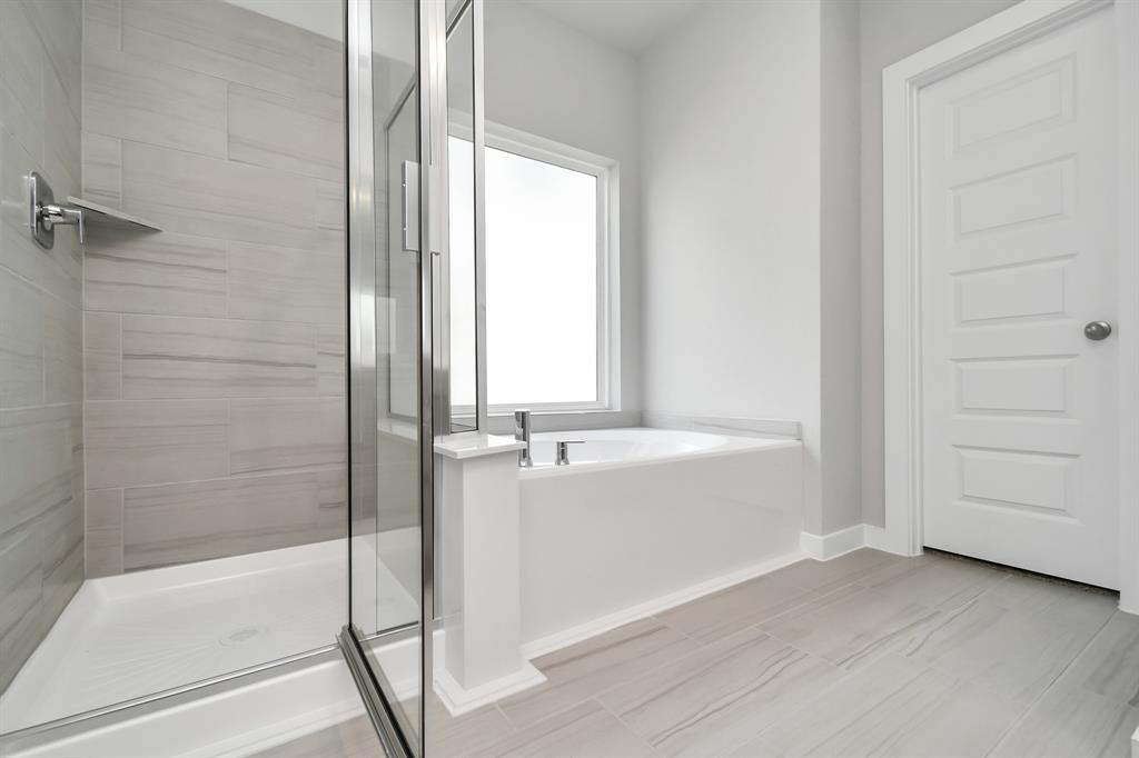 The primary en-suite has a soaking tub to give you that spa experience. The large privacy window allow lots of nature light in the space.