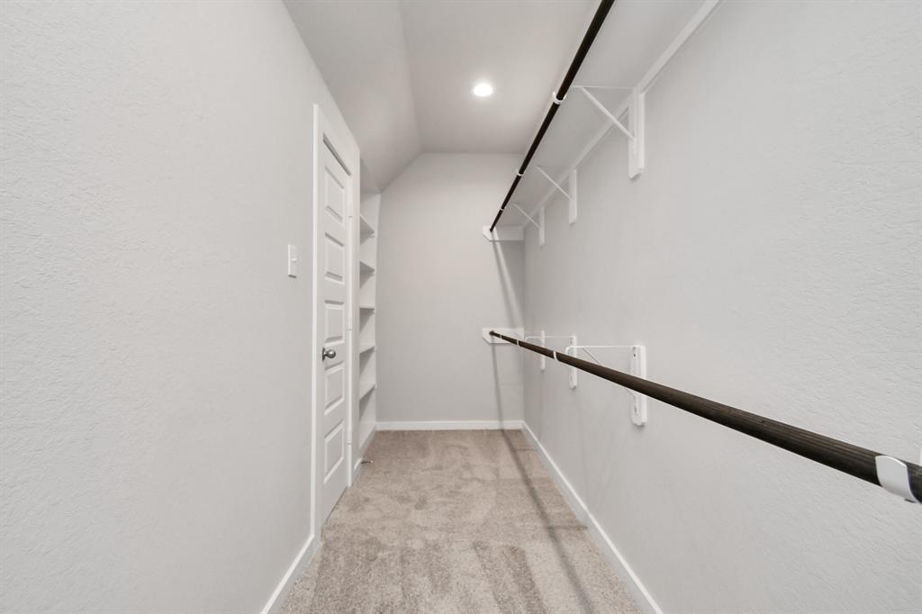 This generously sized walk in closet boasts built-in shelving, providing ample room for organization