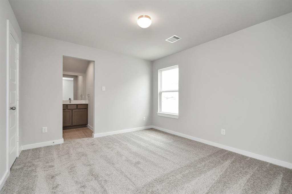 Secondary bedroom features plush carpet, custom paint, large window with privacy blinds and access to the Jack and Jill bath