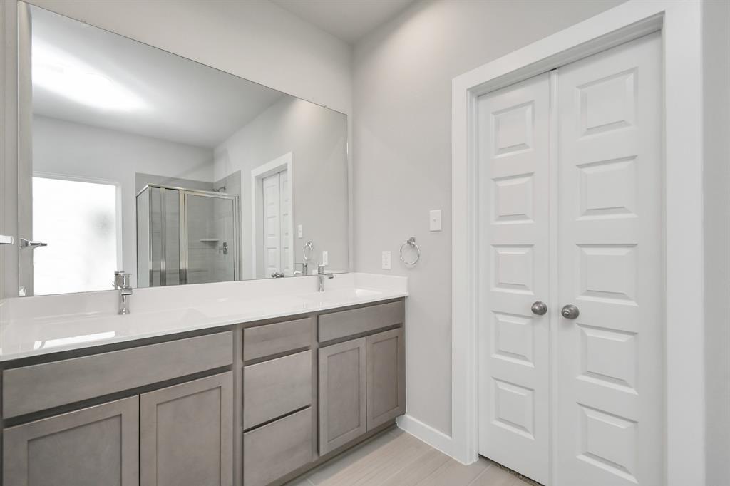 Experience sophistication in the secondary bathroom, where tile flooring complements a bath/shower combo with tile surround. Light wood cabinets complete with a beautiful light countertop, enhances the space for a truly inviting ambiance.