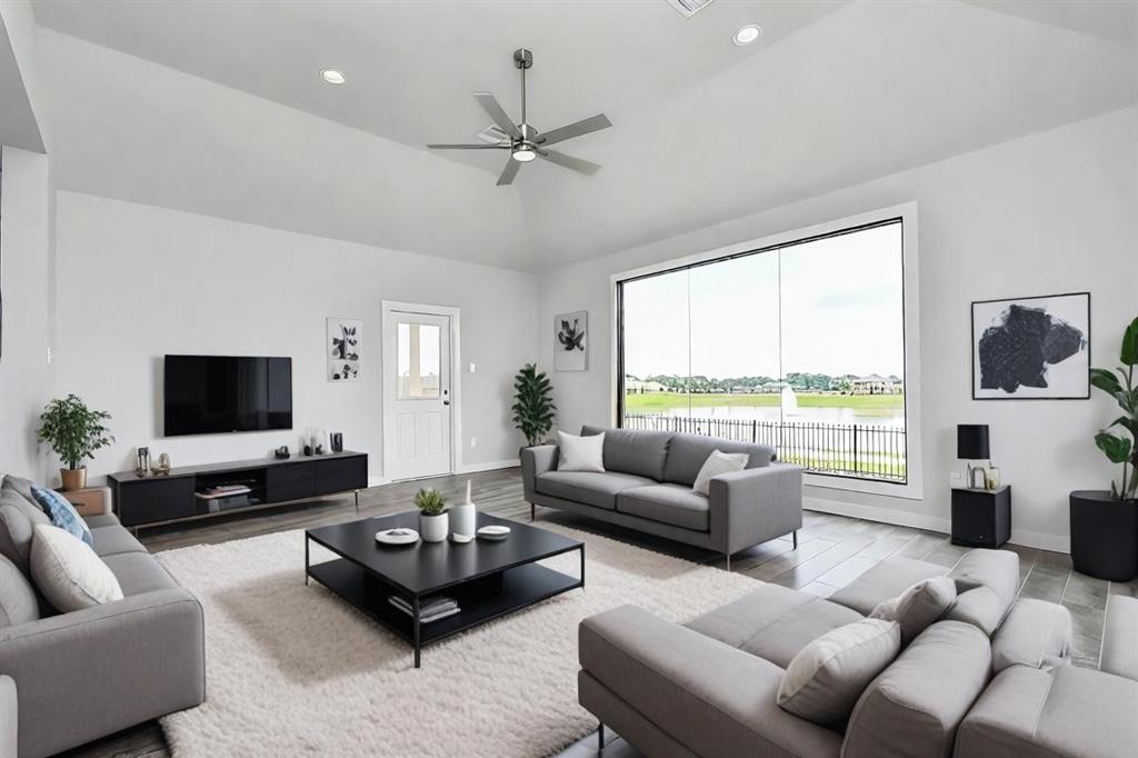 Bring the family and guests together in the welcoming family room! Enjoy the expansive space adorned with high ceilings, recessed lighting, a stylish ceiling fan, custom paint, exquisite flooring, and lake view from the expanisve window!