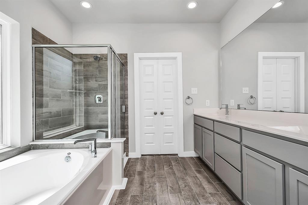 This additional view of the primary bath features a walk-in shower with the tile surround and separate garden tub perfect for soaking after a long day.