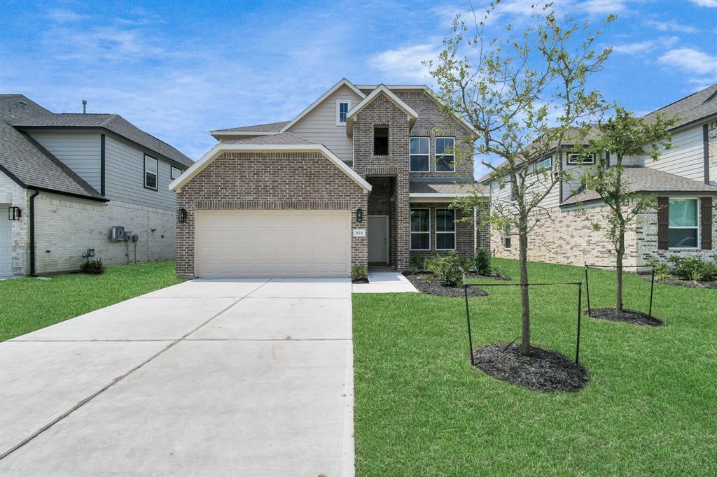 The residence features a practical 2-car garage complemented by a generous driveway, ensuring abundant space for parking needs.