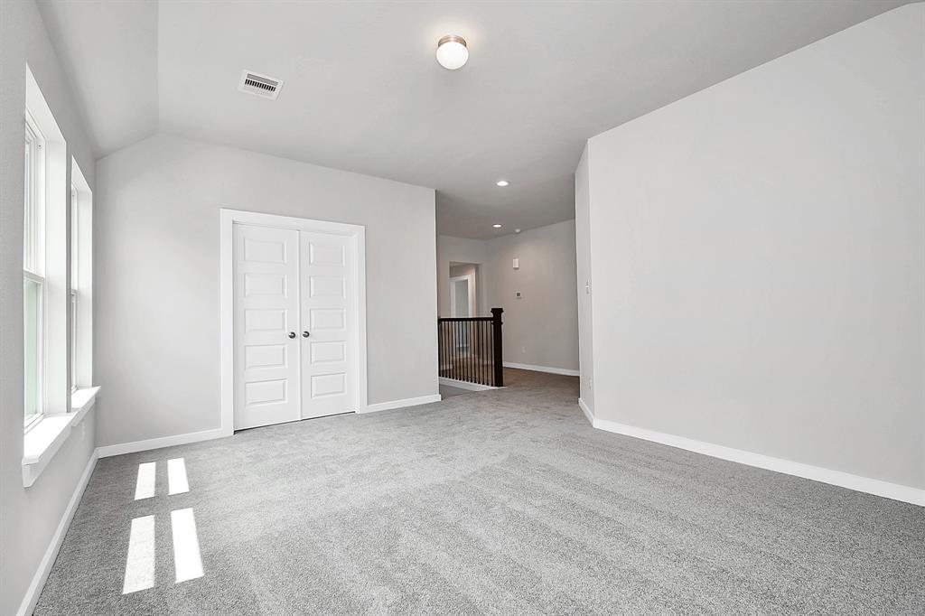 Come upstairs and relish a day of relaxation in this loft area! Ideal as an additional living space or game room, it boasts plush carpeting, high ceilings, custom paint, and windows that flood the area with abundant natural light.