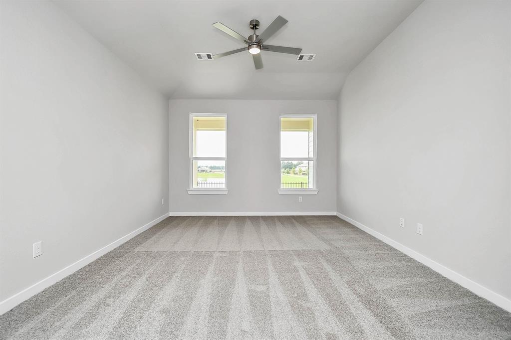 Secondary bedroom features plush carpeting, large windows that let in plenty of natural light, bright paint, and spacious closets.