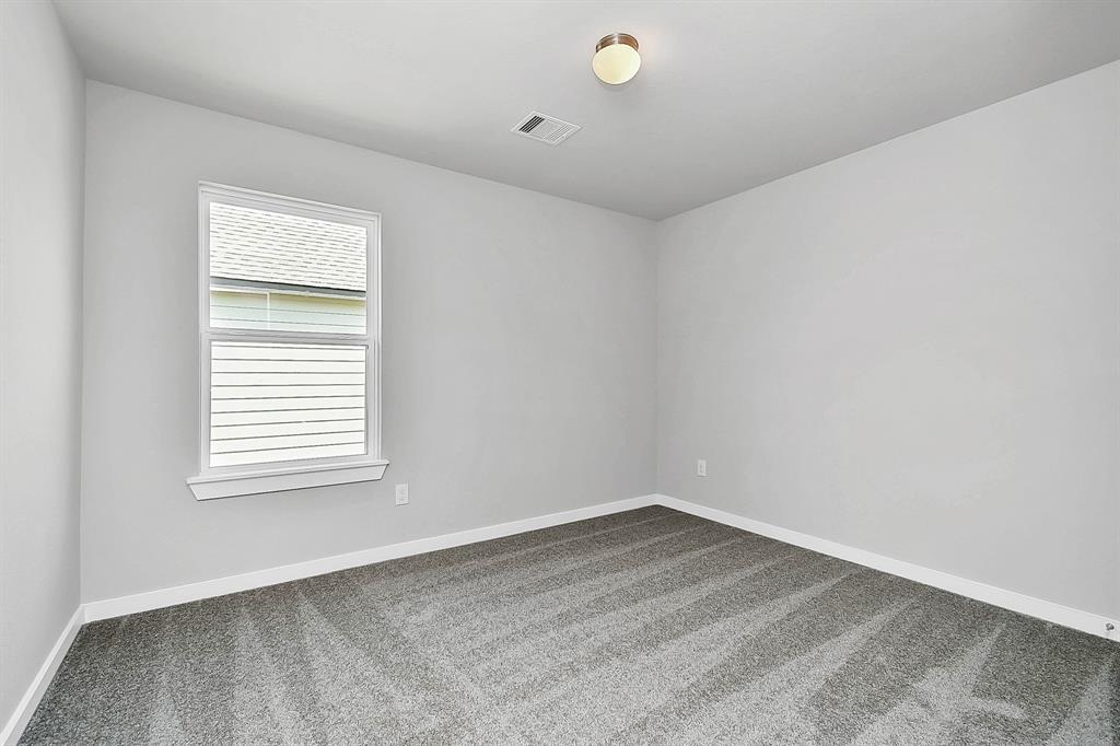 Secondary bedroom features plush carpeting, large windows that let in plenty of natural light, bright paint, and spacious closets.